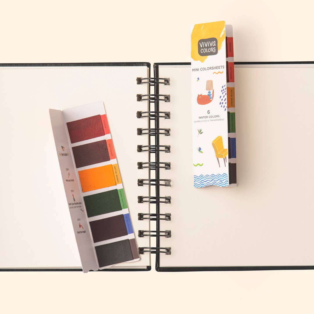 Color swatch book and Vivienne watercolor set on a notebook